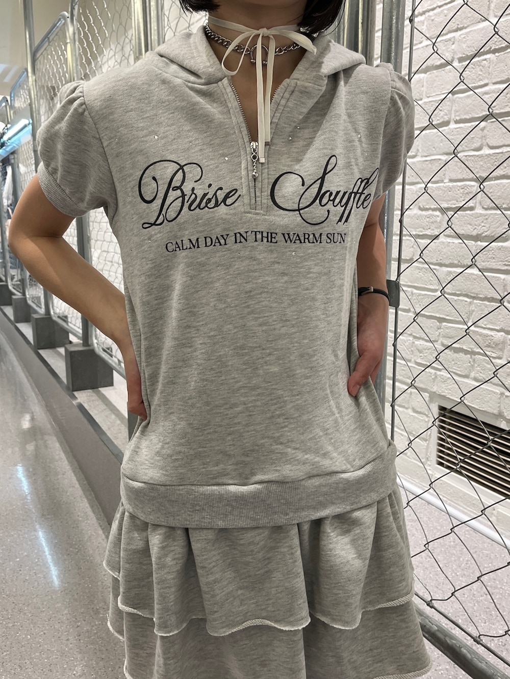 グレー系のワンピース、ブラック系のキャップ、ブラック系のチョーカーを着用したレディースの夏コーディネートの7枚目の写真