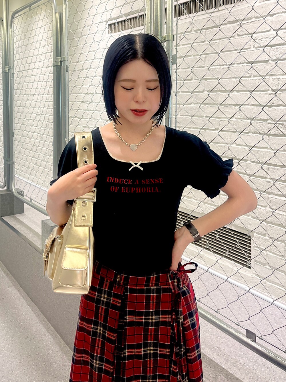 ブラック系のTシャツ/カットソー、レッド系のスカート、ブラック系のパンプスを着用したレディースの夏コーディネートの5枚目の写真