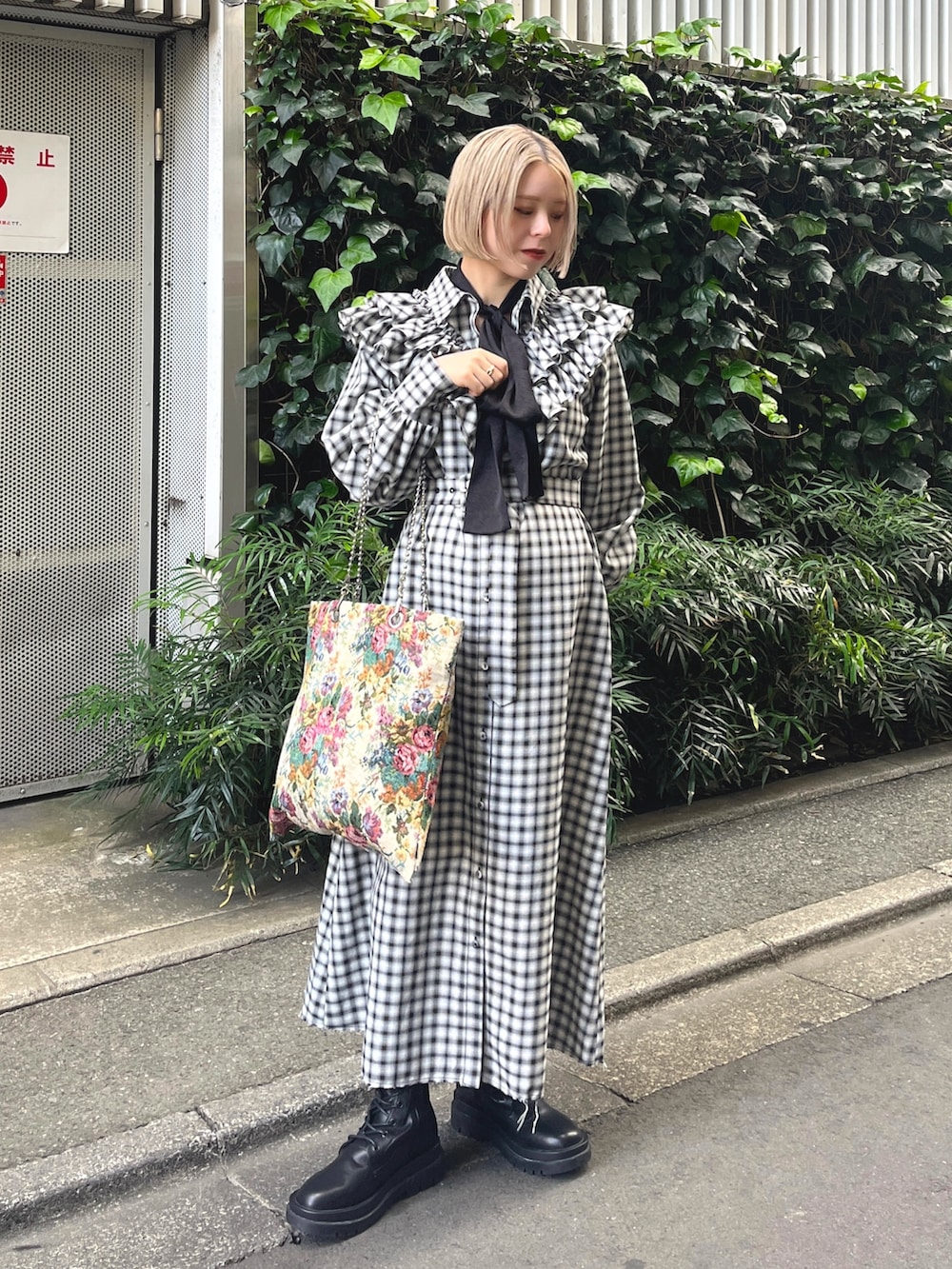 ブラック系のワンピース、ホワイト系のトートバッグ、ブラック系のブーツを着用したレディースの冬コーディネートの2枚目の写真