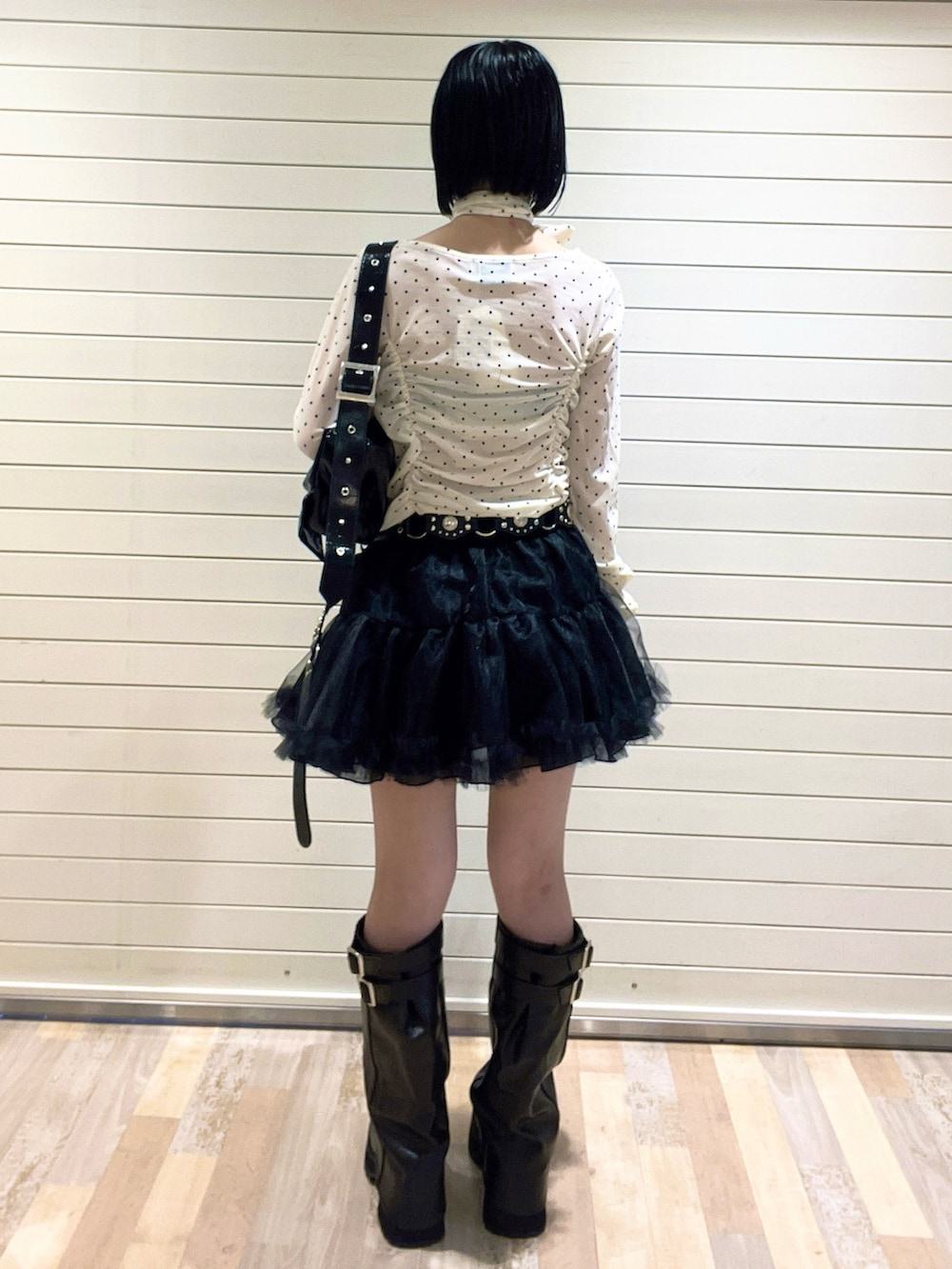 ホワイト系のTシャツ/カットソー、ブラック系のブーツ、ブラック系のスカートを着用したレディースの秋コーディネートの5枚目の写真