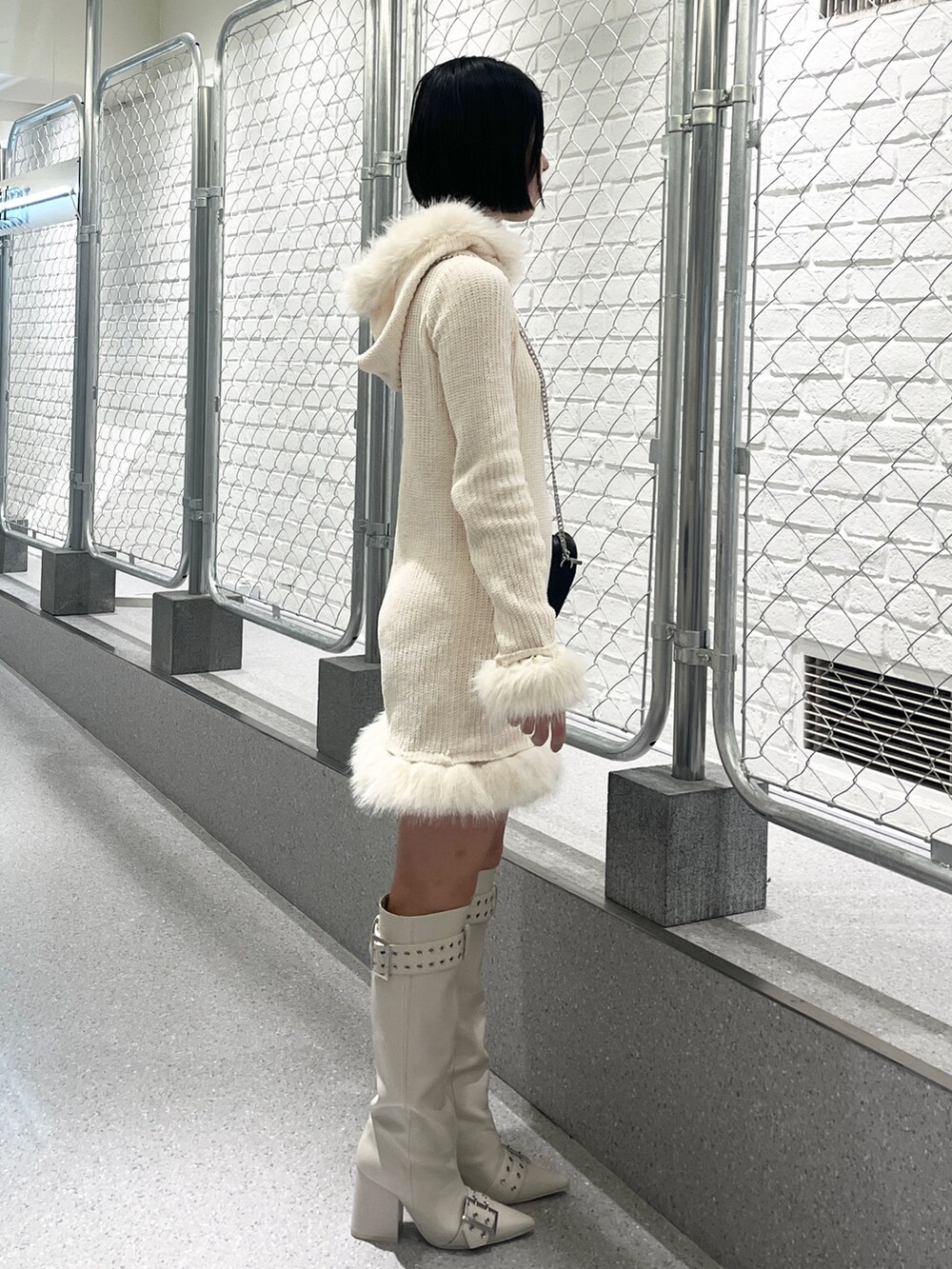 ホワイト系のワンピース、ホワイト系のブーツを着用したレディースの冬コーディネートの3枚目の写真