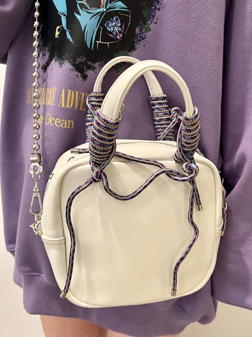 ブラック系のブーツ、ホワイト系のシャツ/ブラウス、パープル系のスウェットを着用したレディースの秋コーディネートの8枚目の写真