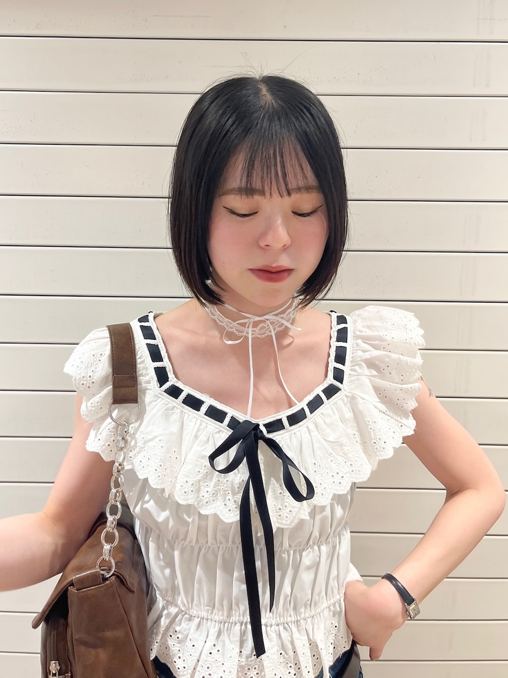 ホワイト系のシャツ/ブラウス、ブルー系のデニムパンツ、ブラウン系のハンドバッグを着用したレディースの春コーディネートの5枚目の写真