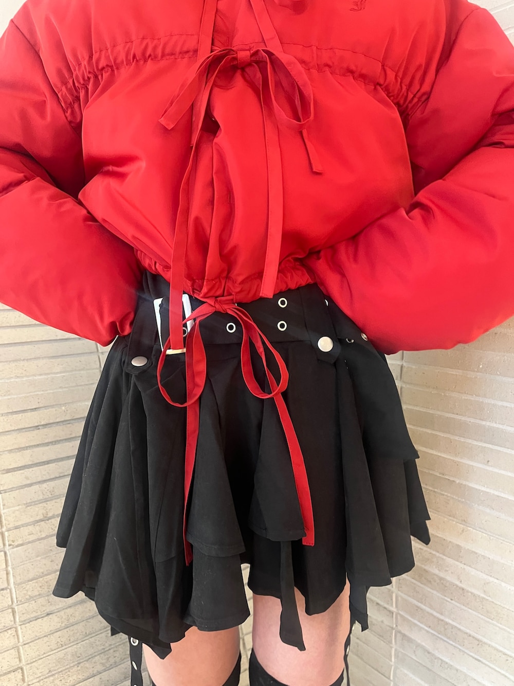 レッド系のブルゾン、ブラック系のスカートを着用したレディースの冬コーディネートの7枚目の写真