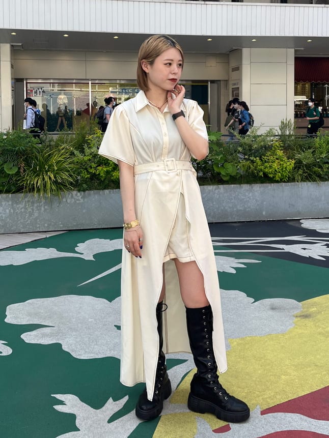 ブラック系のブーツ、ホワイト系のワンピース、ゴールド系のネックレスを着用したレディースの春コーディネートの3枚目の写真