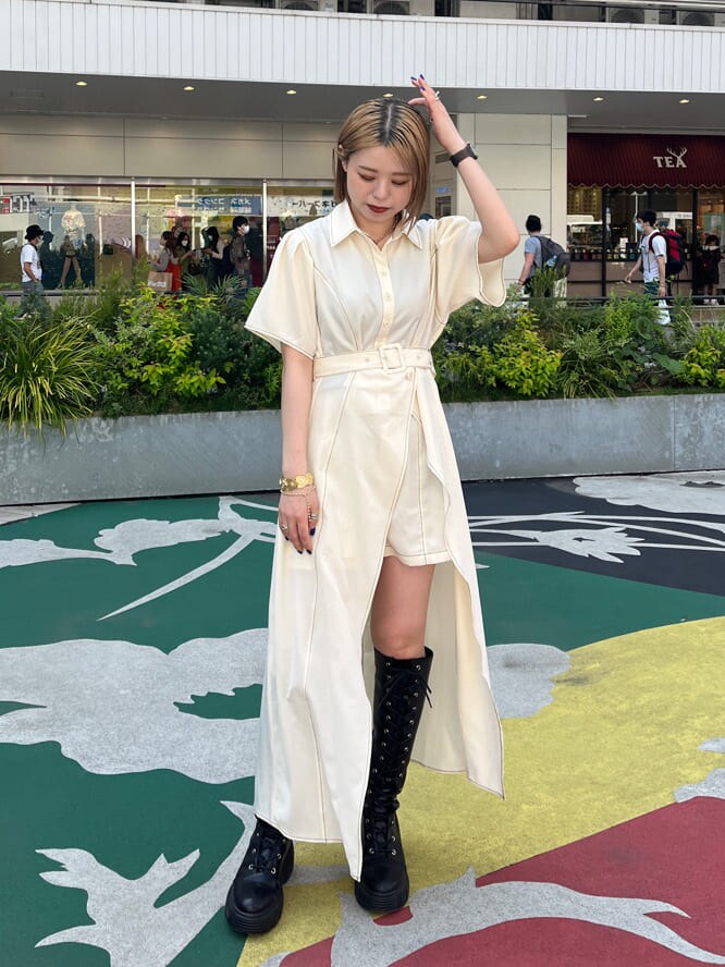 ブラック系のブーツ、ホワイト系のワンピース、ゴールド系のネックレスを着用したレディースの春コーディネートの2枚目の写真