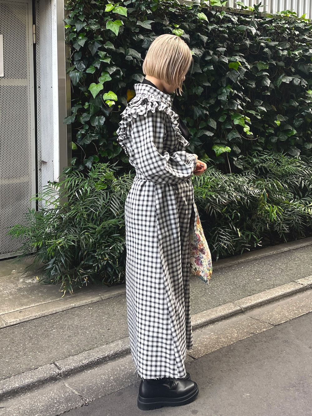 ブラック系のワンピース、ホワイト系のトートバッグ、ブラック系のブーツを着用したレディースの冬コーディネートの3枚目の写真