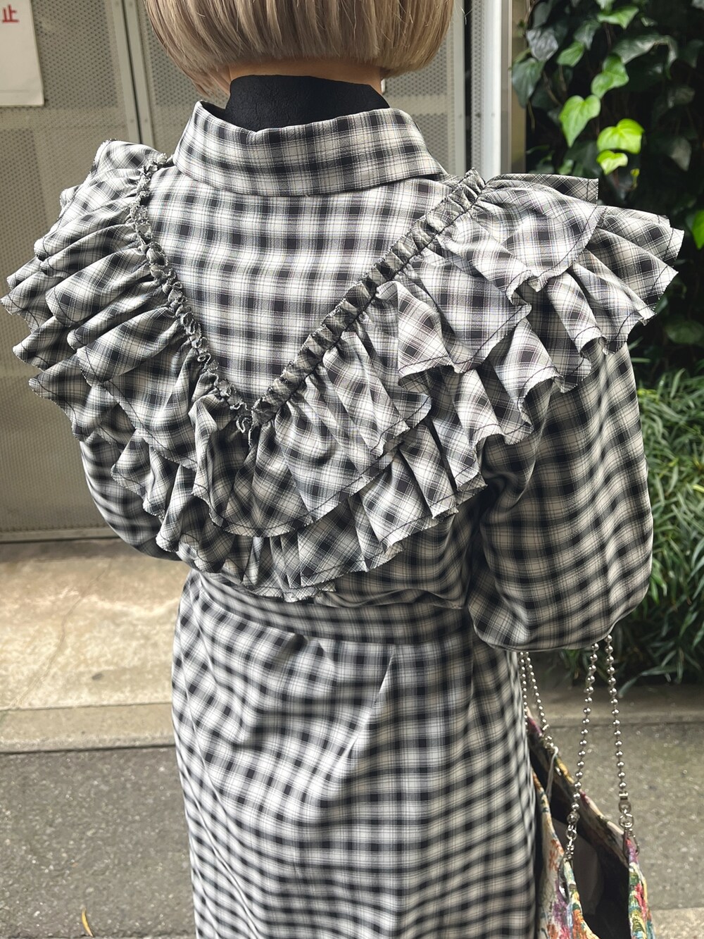 ブラック系のワンピース、ホワイト系のトートバッグ、ブラック系のブーツを着用したレディースの冬コーディネートの8枚目の写真