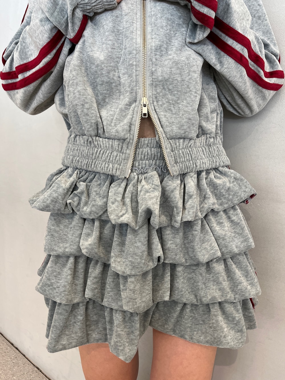 グレー系のパーカー、グレー系のスカート、ブルー系のブーツを着用したレディースの夏コーディネートの9枚目の写真