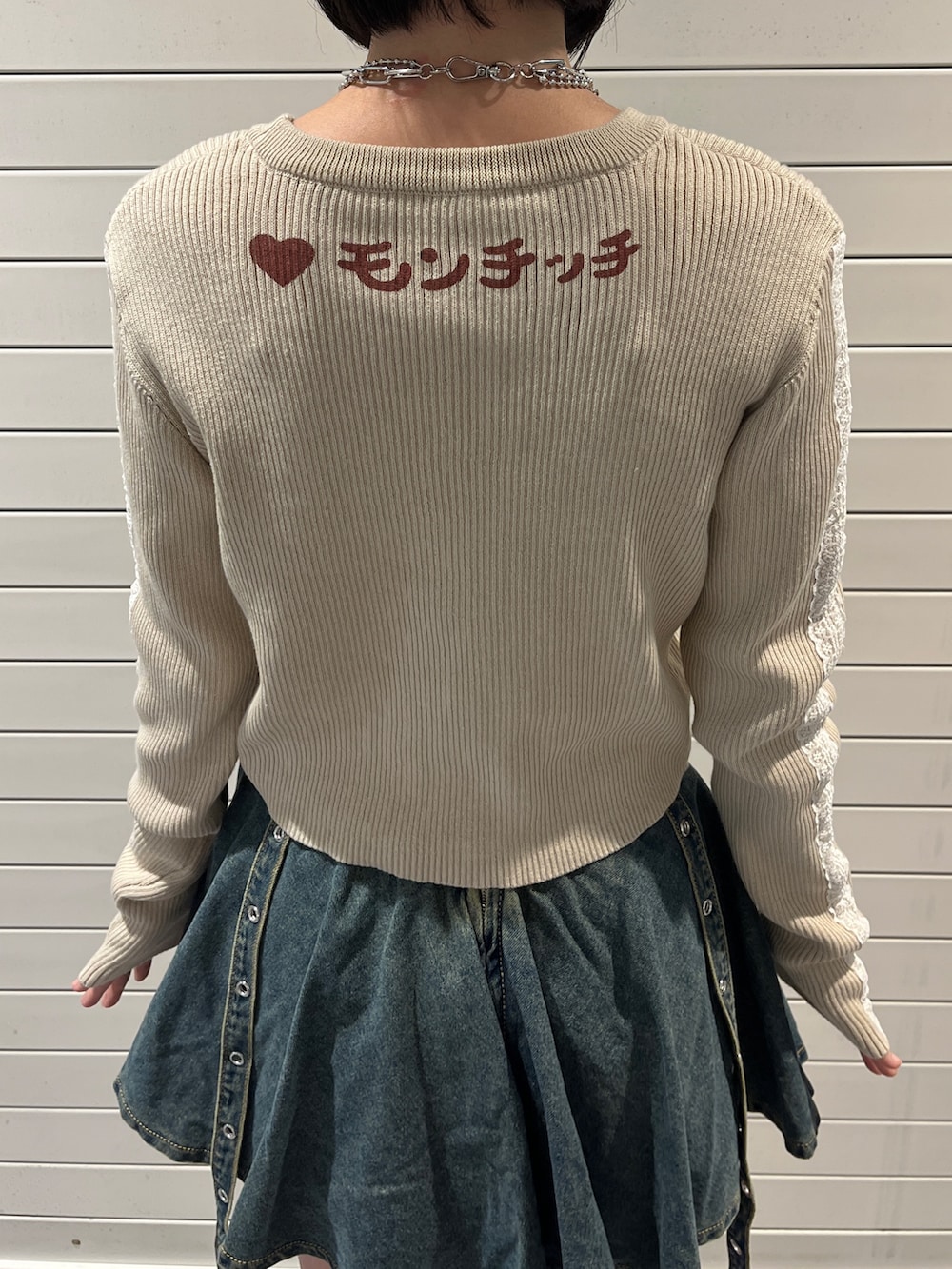 ホワイト系のニット/セーター、ブルー系のデニムスカート、ブラウン系のキャップを着用したレディースの秋コーディネートの7枚目の写真