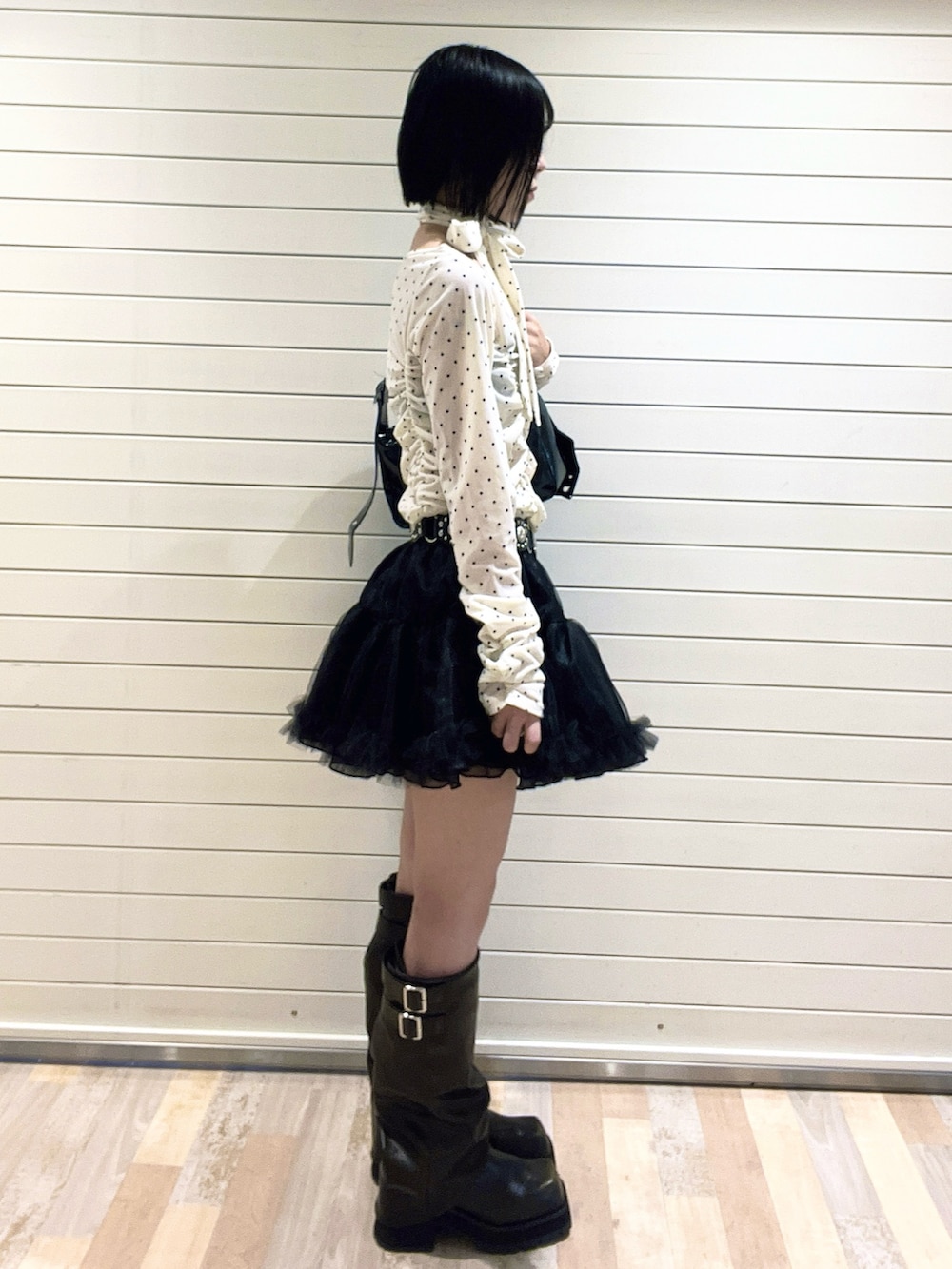 ホワイト系のTシャツ/カットソー、ブラック系のブーツ、ブラック系のスカートを着用したレディースの秋コーディネートの4枚目の写真