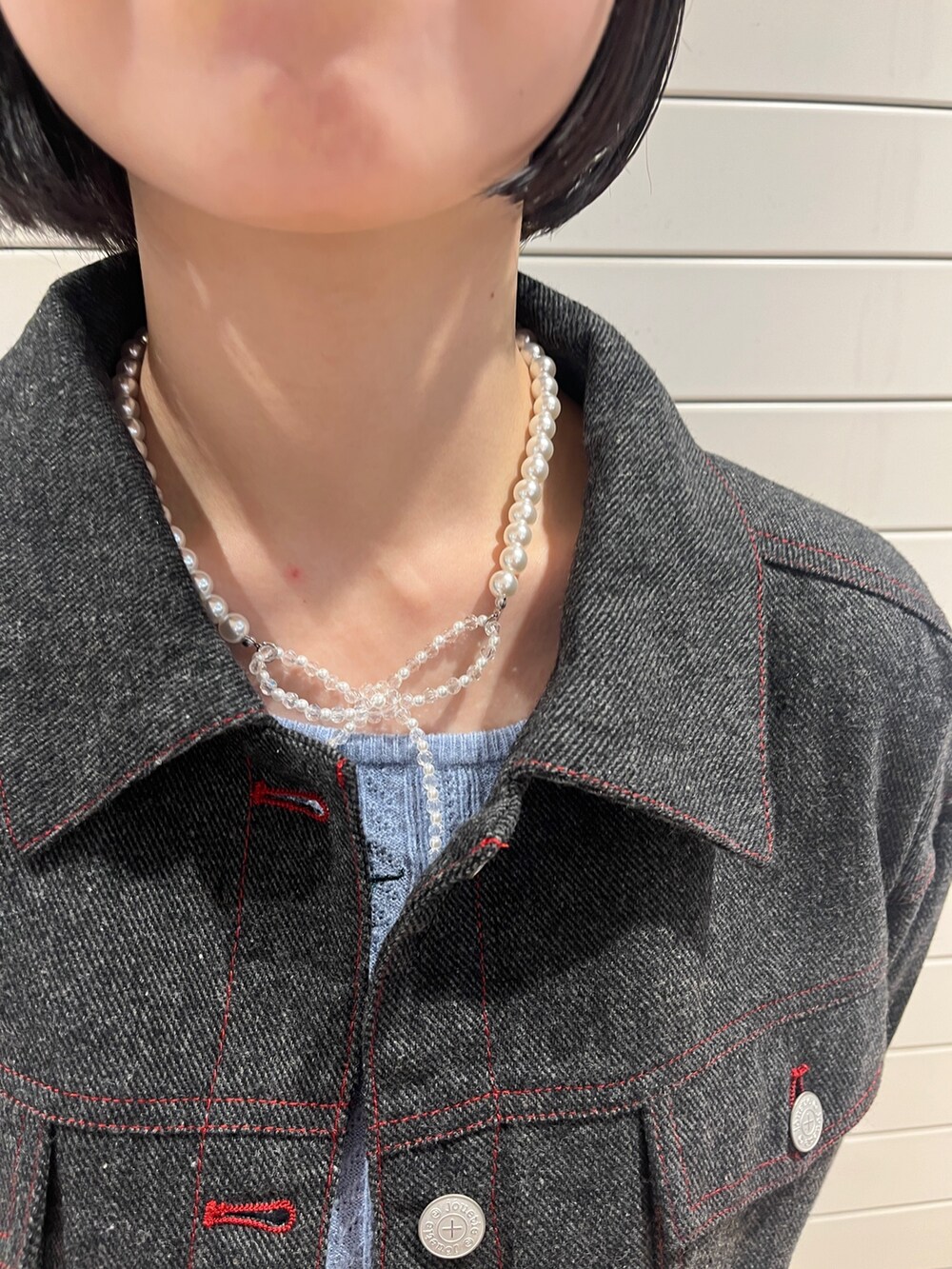 グレー系のワンピース、ブルー系のニット/セーター、ブラック系のハンドバッグを着用したレディースの秋コーディネートの7枚目の写真