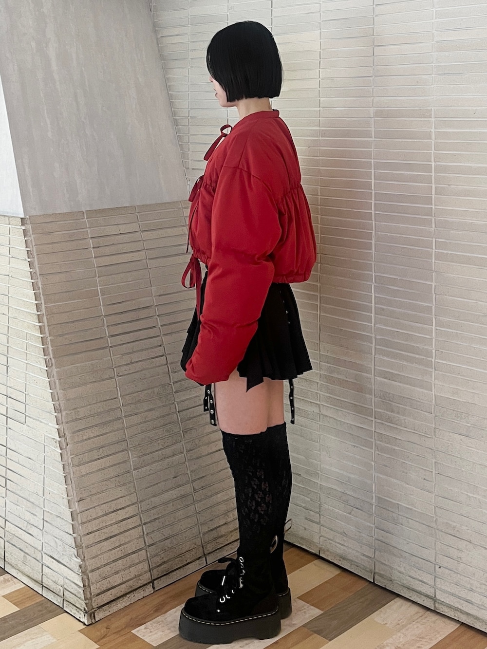 レッド系のブルゾン、ブラック系のスカートを着用したレディースの冬コーディネートの3枚目の写真