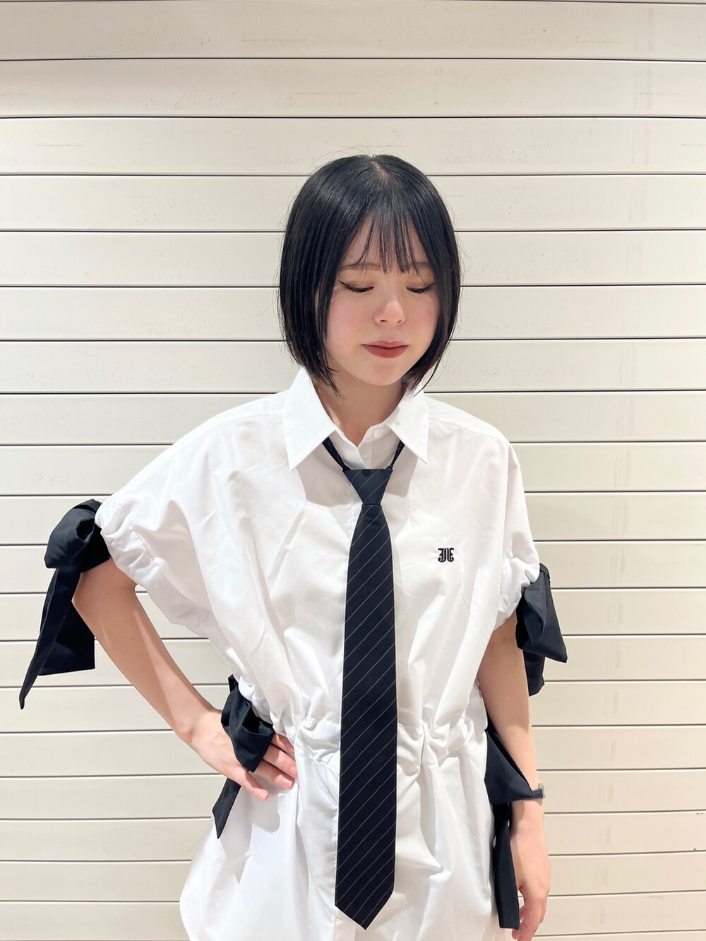 ブラック系のネクタイ、ブラック系のブーツ、ホワイト系のシャツ/ブラウスを着用したレディースの夏コーディネートの5枚目の写真