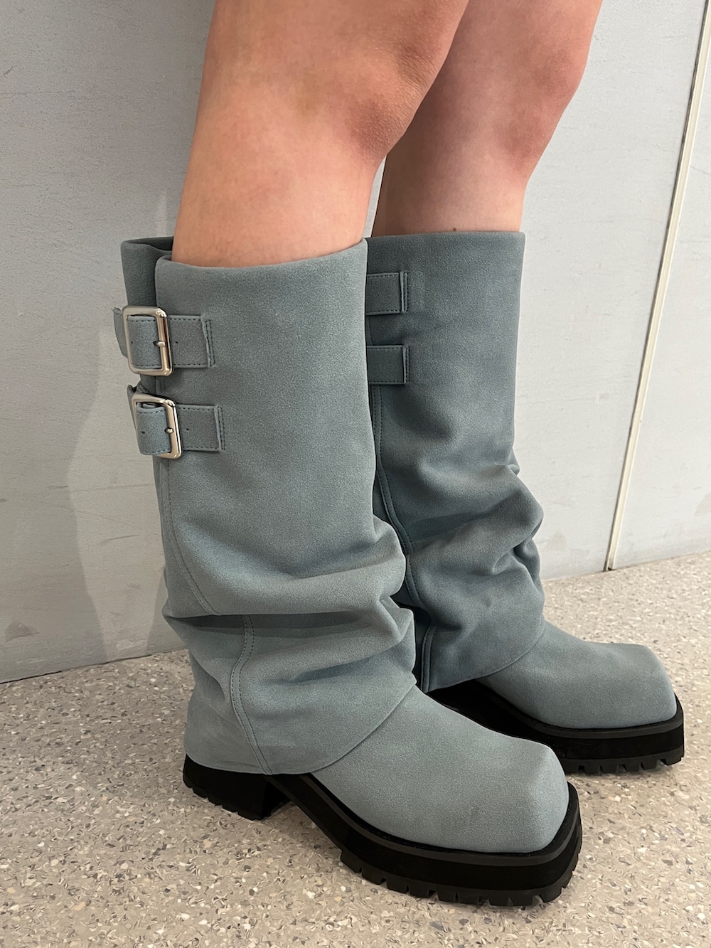 グレー系のパーカー、グレー系のスカート、ブルー系のブーツを着用したレディースの夏コーディネートの10枚目の写真