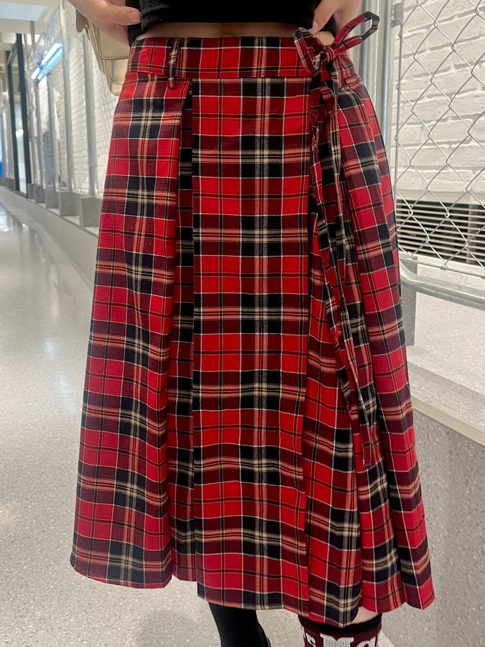 ブラック系のTシャツ/カットソー、レッド系のスカート、ブラック系のパンプスを着用したレディースの夏コーディネートの7枚目の写真