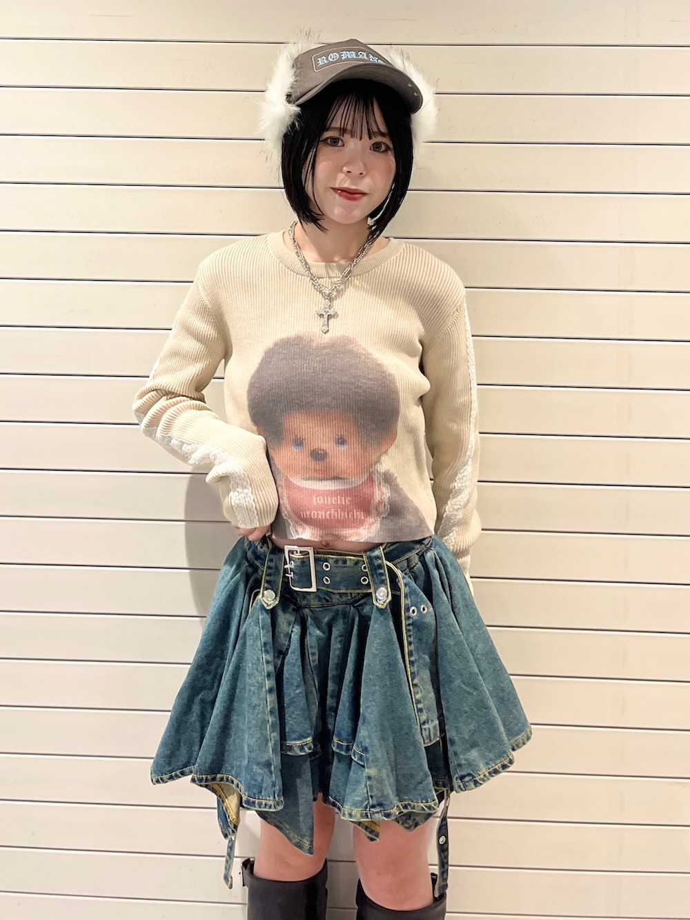 ホワイト系のニット/セーター、ブルー系のデニムスカート、ブラウン系のキャップを着用したレディースの秋コーディネートの5枚目の写真