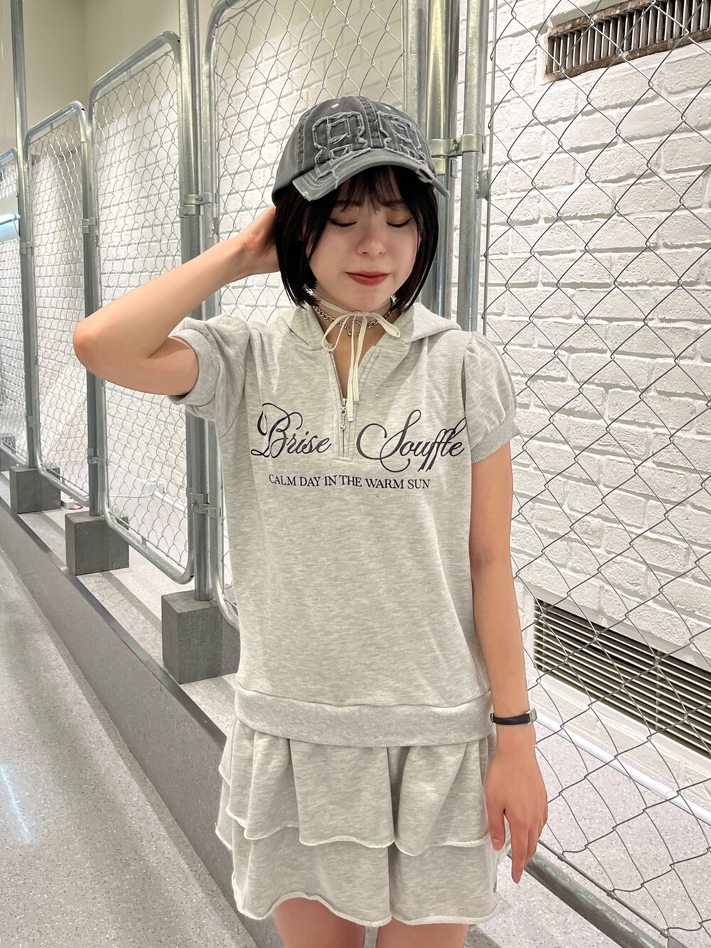 グレー系のワンピース、ブラック系のキャップ、ブラック系のチョーカーを着用したレディースの夏コーディネートの5枚目の写真