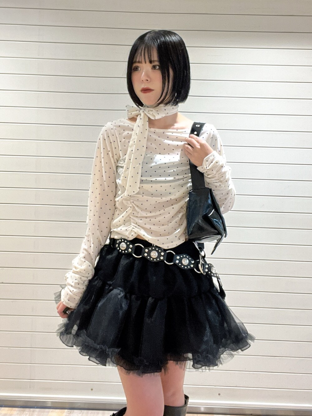 ホワイト系のTシャツ/カットソー、ブラック系のブーツ、ブラック系のスカートを着用したレディースの秋コーディネートの6枚目の写真