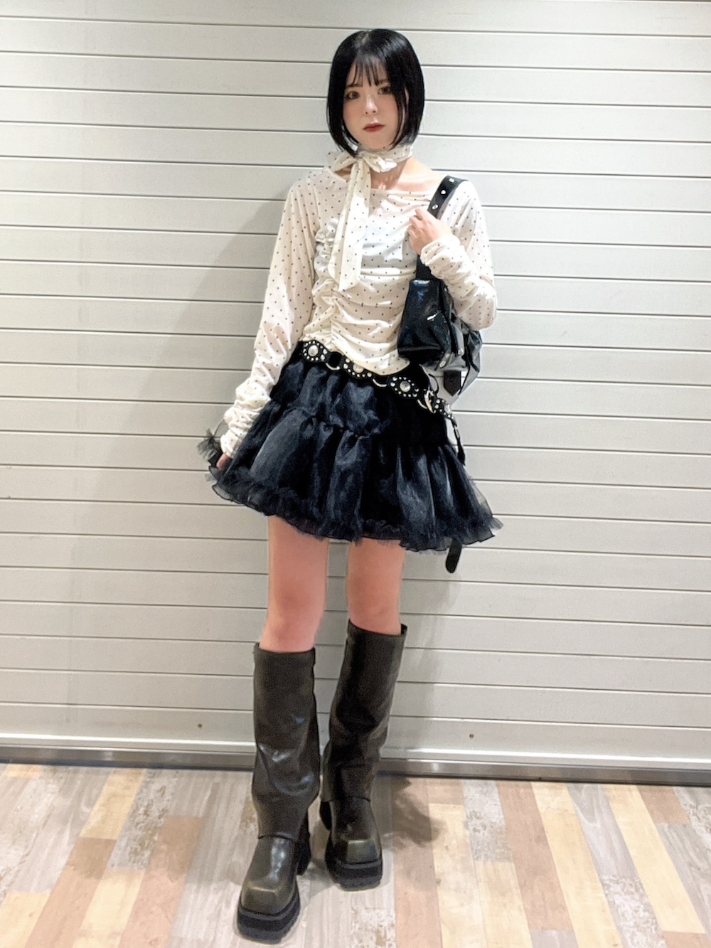 ホワイト系のTシャツ/カットソー、ブラック系のブーツ、ブラック系のスカートを着用したレディースの秋コーディネートの3枚目の写真