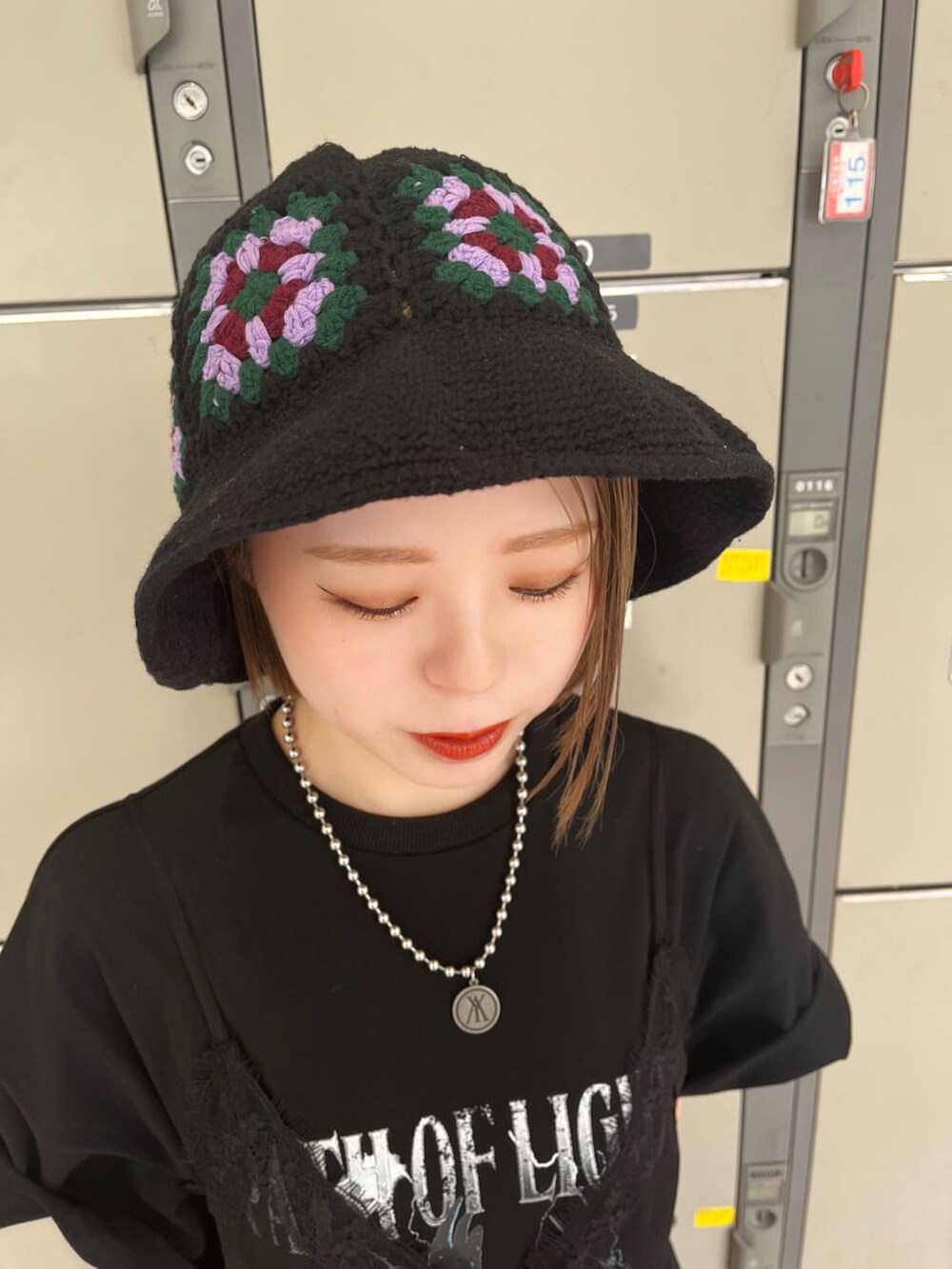 ブラック系のブーツ、ブラック系のワンピース、シルバー系のブレスレットを着用したレディースの春コーディネートの5枚目の写真