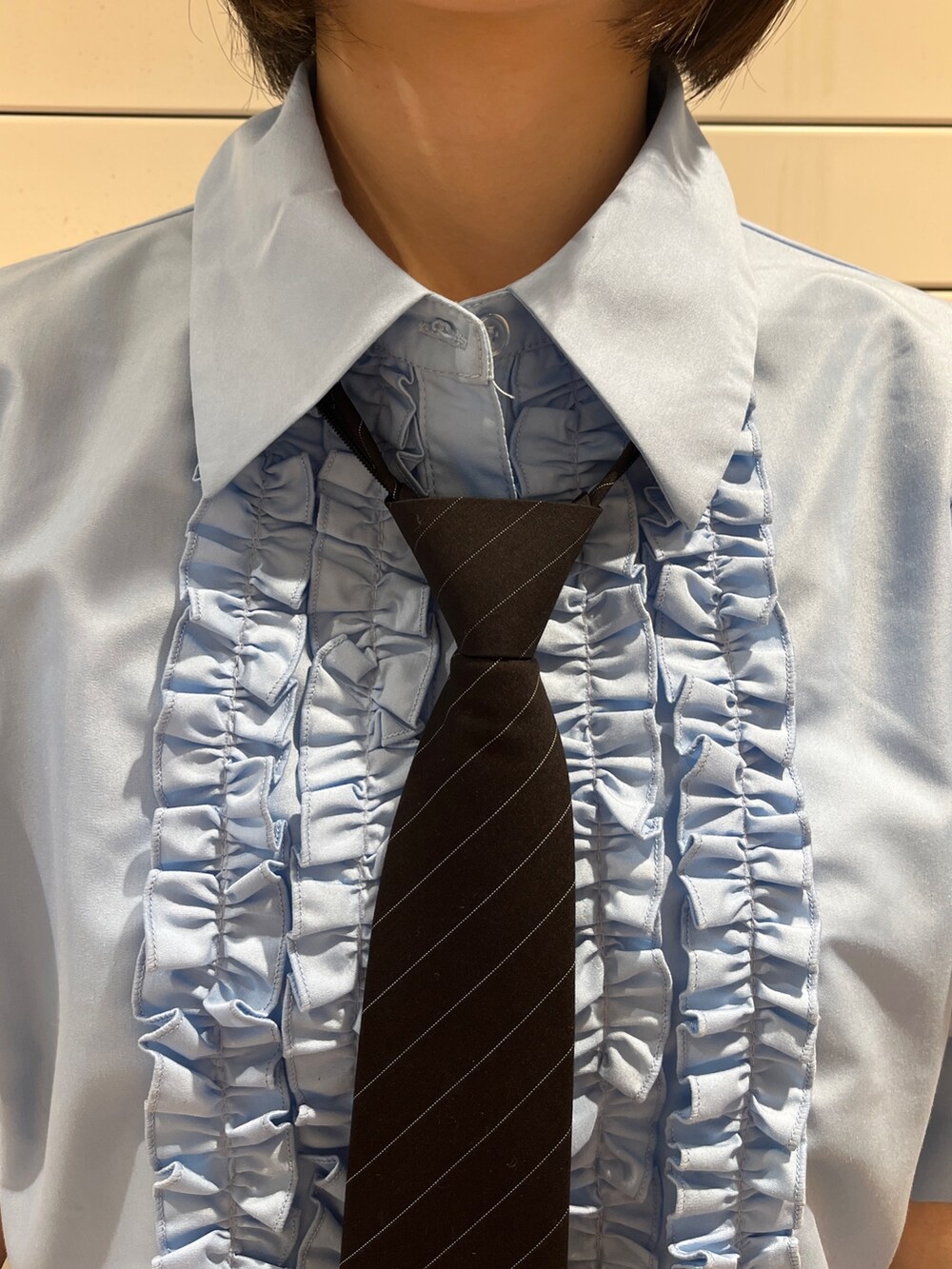 ブルー系のシャツ/ブラウス、ブラック系のネクタイ、ブラック系のスカートを着用したレディースの夏コーディネートの6枚目の写真