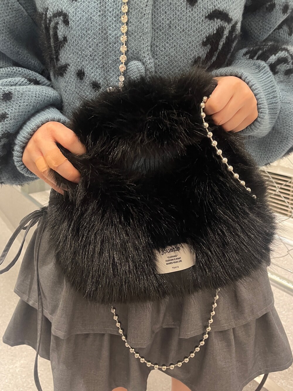 シルバー系のブーツ、ブルー系のカーディガン/ボレロ、ブラック系のハンドバッグを着用したレディースの夏コーディネートの10枚目の写真