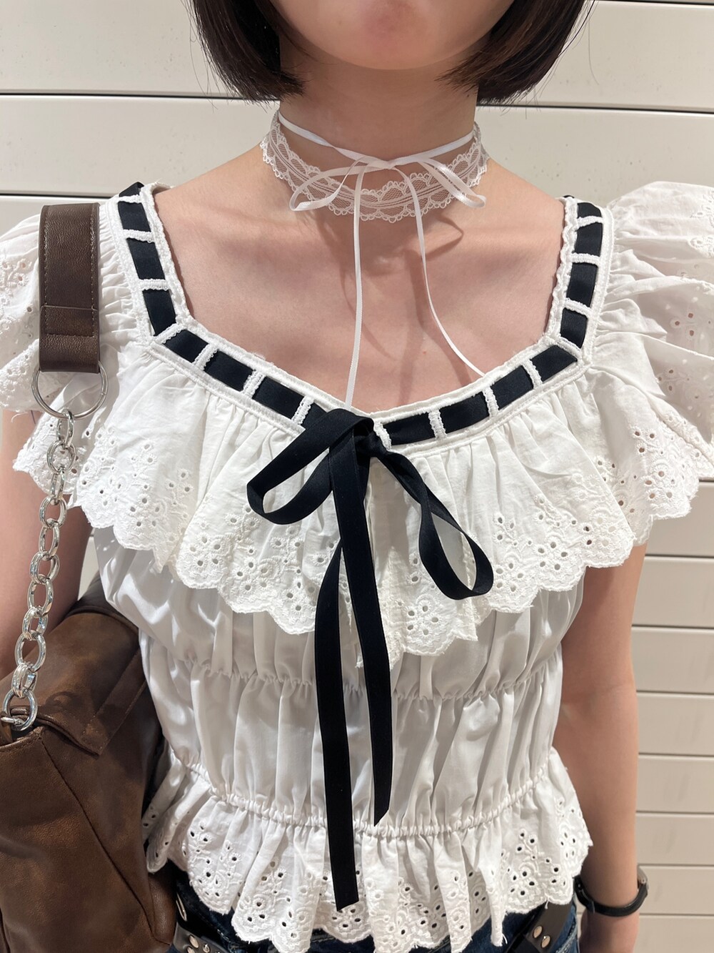 ホワイト系のシャツ/ブラウス、ブルー系のデニムパンツ、ブラウン系のハンドバッグを着用したレディースの春コーディネートの6枚目の写真