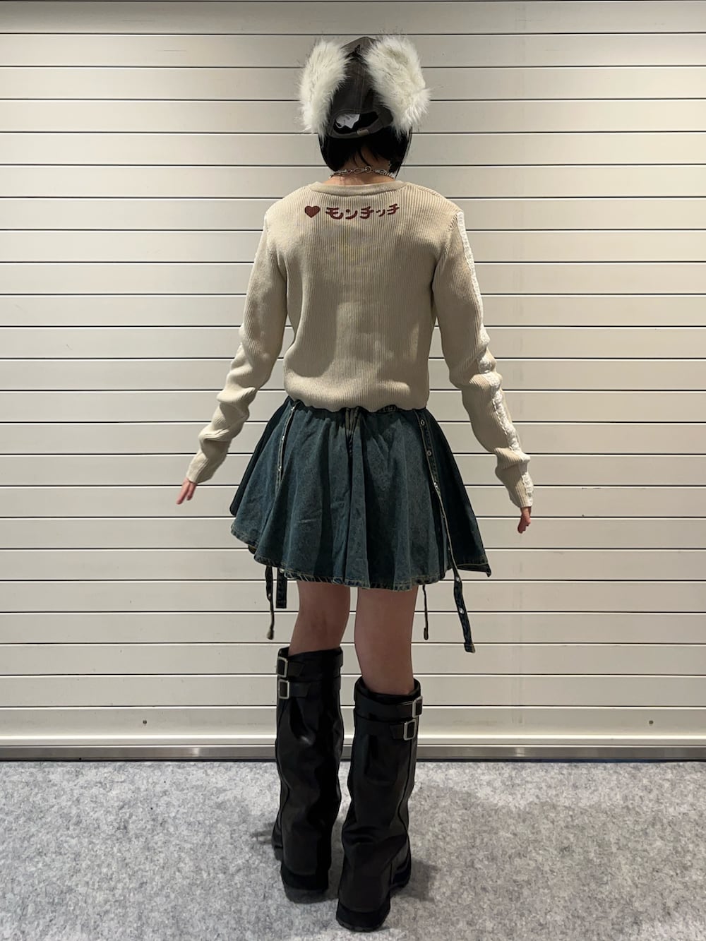 ホワイト系のニット/セーター、ブルー系のデニムスカート、ブラウン系のキャップを着用したレディースの秋コーディネートの4枚目の写真