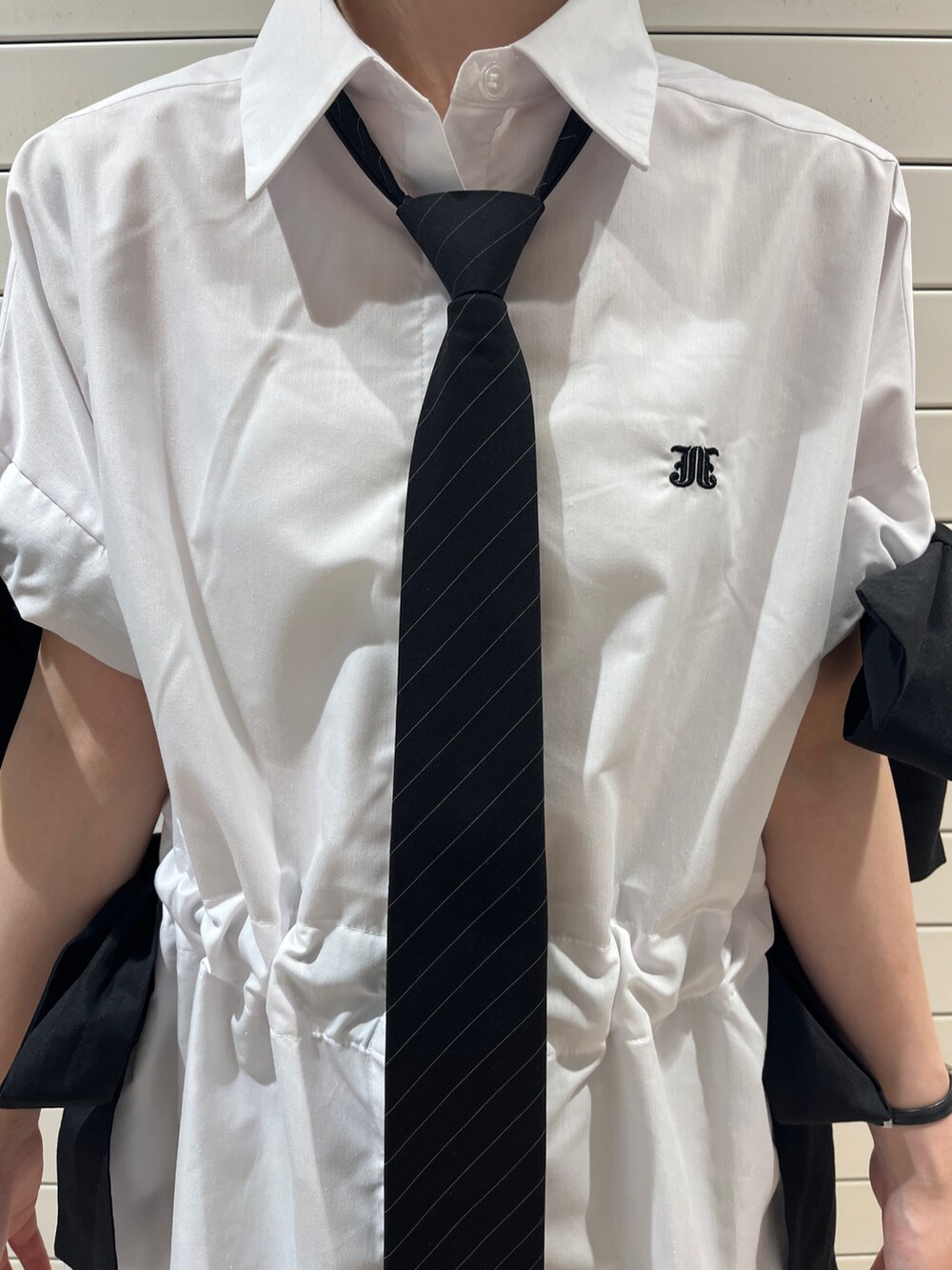 ブラック系のネクタイ、ブラック系のブーツ、ホワイト系のシャツ/ブラウスを着用したレディースの夏コーディネートの6枚目の写真