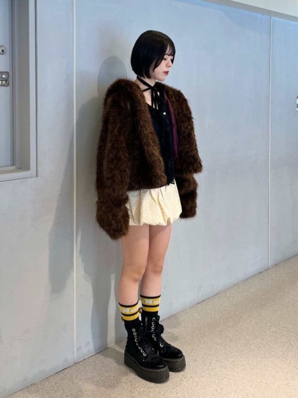 ホワイト系のスカート、ブラウン系のブルゾン、ブラック系のニット/セーターを着用したレディースの秋コーディネートの3枚目の写真