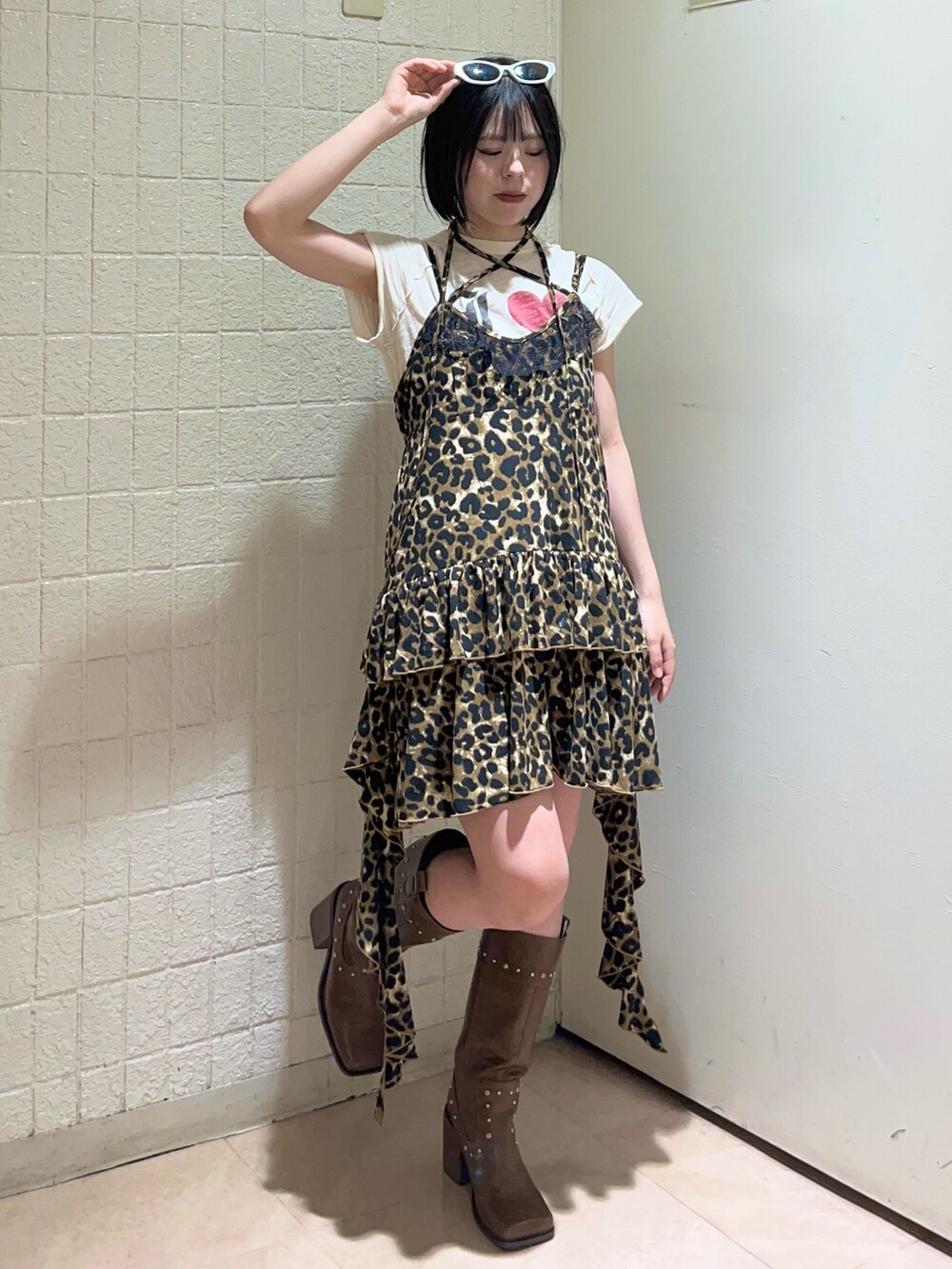 ブラウン系のワンピース、ホワイト系のTシャツ/カットソー、ブラウン系のブーツを着用したレディースの夏コーディネートの2枚目の写真