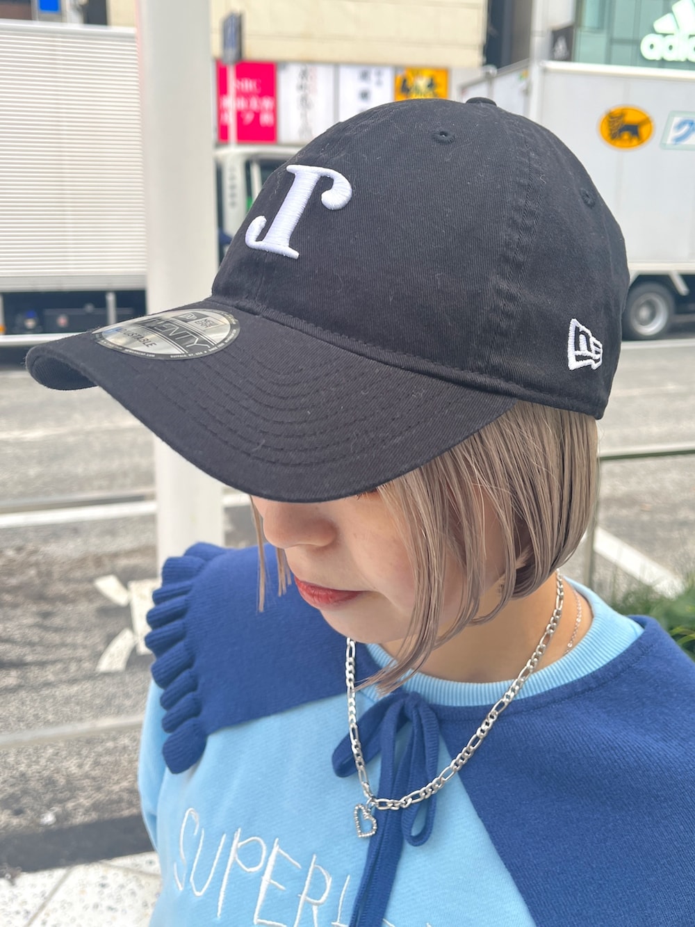 ブラック系のハンドバッグ、ブルー系のニット/セーター、グレー系のスカートを着用したレディースの冬コーディネートの9枚目の写真