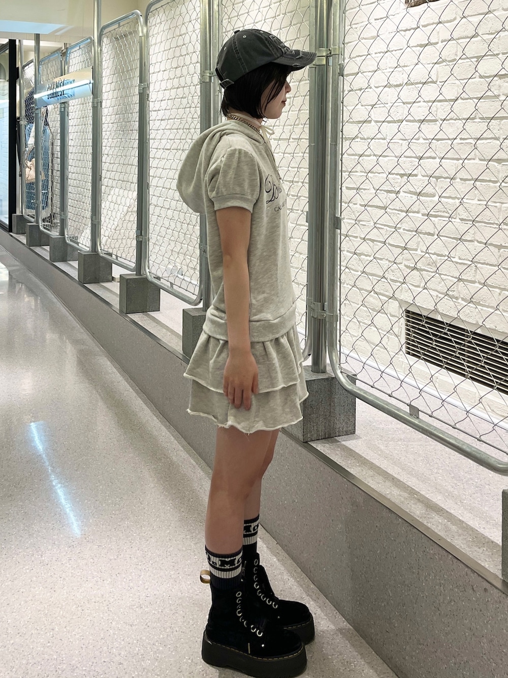 グレー系のワンピース、ブラック系のキャップ、ブラック系のチョーカーを着用したレディースの夏コーディネートの3枚目の写真