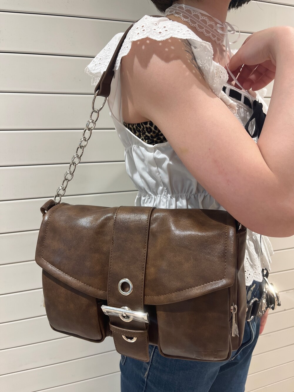 ホワイト系のシャツ/ブラウス、ブルー系のデニムパンツ、ブラウン系のハンドバッグを着用したレディースの春コーディネートの9枚目の写真