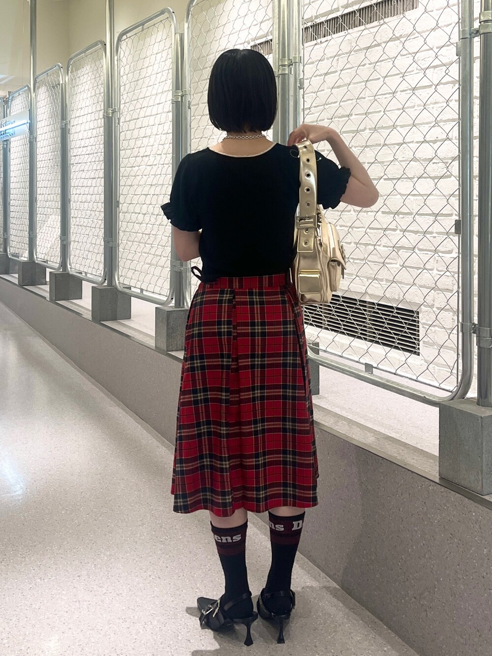 ブラック系のTシャツ/カットソー、レッド系のスカート、ブラック系のパンプスを着用したレディースの夏コーディネートの4枚目の写真