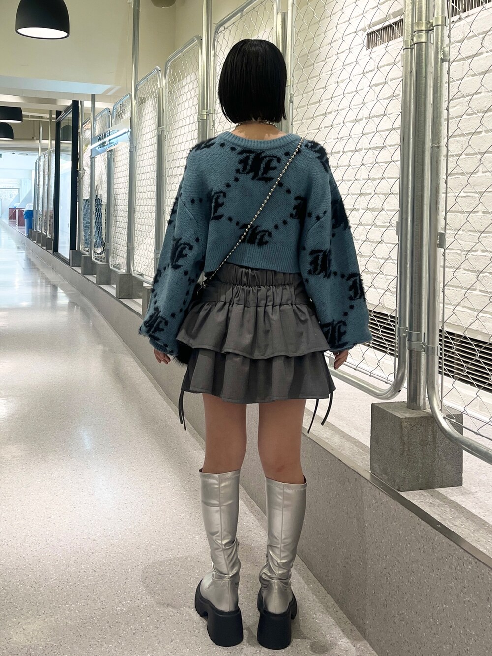 シルバー系のブーツ、ブルー系のカーディガン/ボレロ、ブラック系のハンドバッグを着用したレディースの夏コーディネートの4枚目の写真