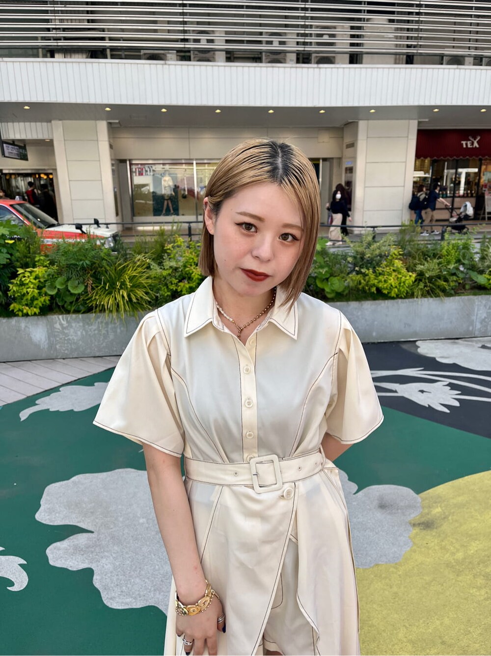 ブラック系のブーツ、ホワイト系のワンピース、ゴールド系のネックレスを着用したレディースの春コーディネートの5枚目の写真