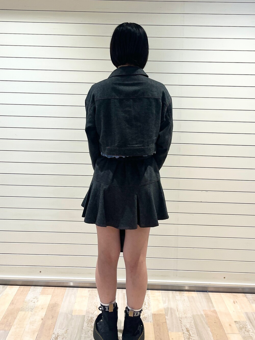 グレー系のワンピース、ブルー系のニット/セーター、ブラック系のハンドバッグを着用したレディースの秋コーディネートの4枚目の写真