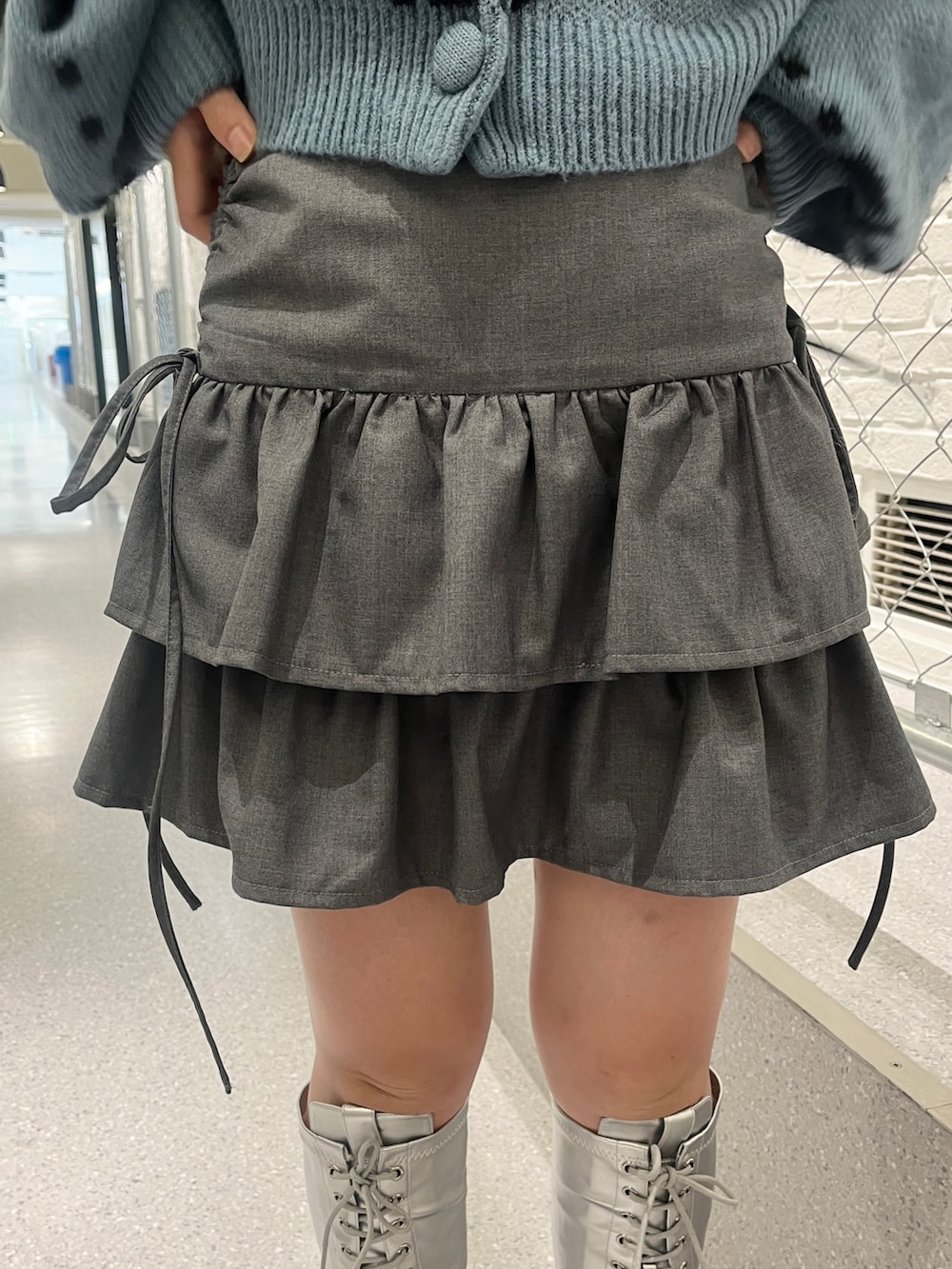 シルバー系のブーツ、ブルー系のカーディガン/ボレロ、ブラック系のハンドバッグを着用したレディースの夏コーディネートの7枚目の写真