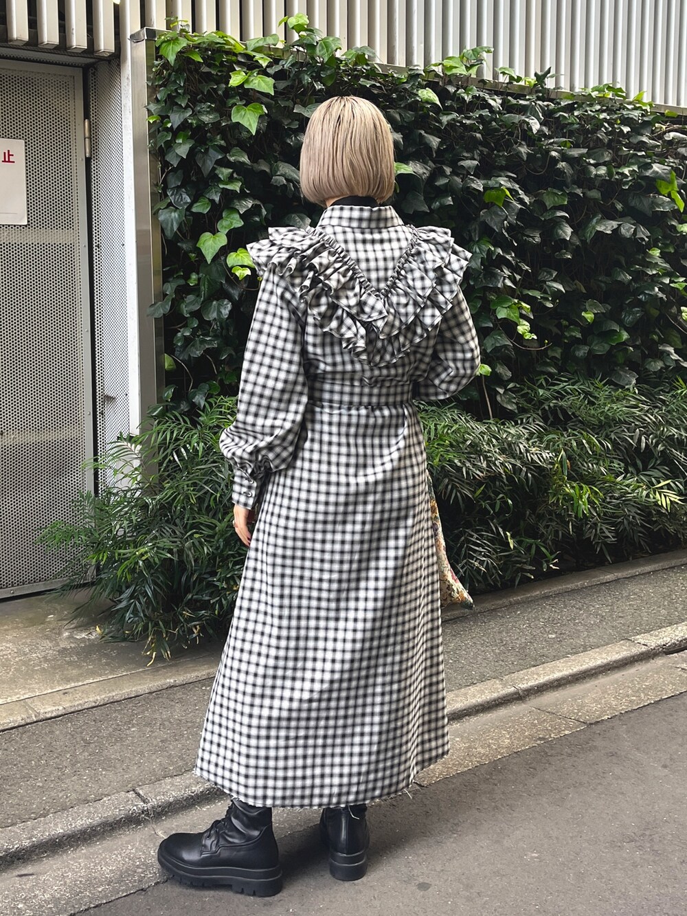 ブラック系のワンピース、ホワイト系のトートバッグ、ブラック系のブーツを着用したレディースの冬コーディネートの4枚目の写真