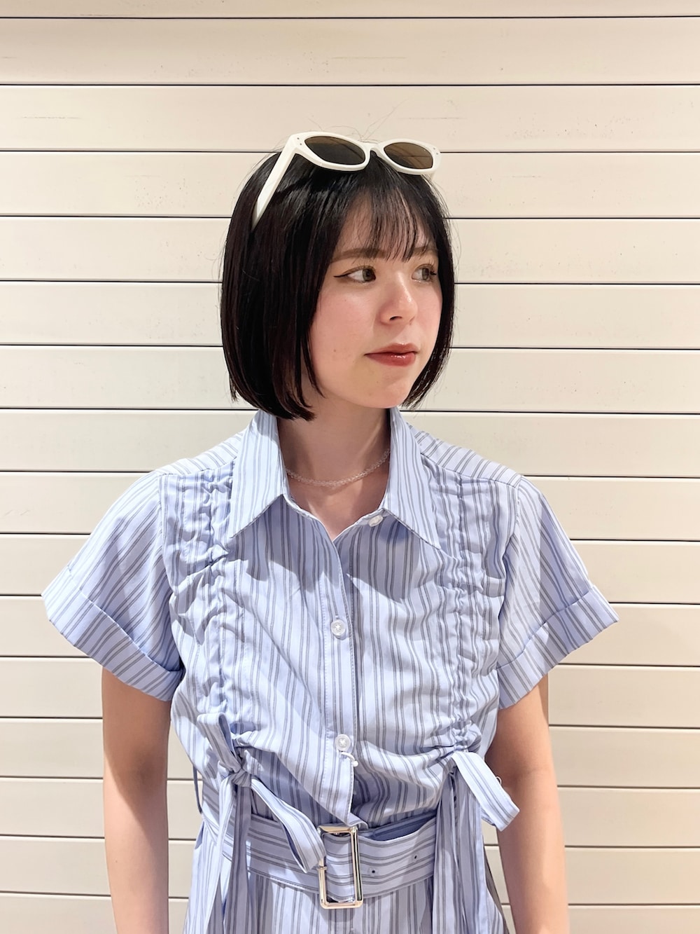 ブルー系のワンピース、ホワイト系のサングラスを着用したレディースの春コーディネートの5枚目の写真