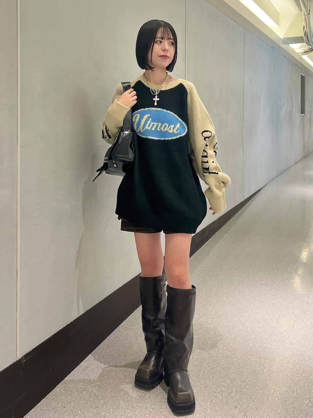 ブラック系のニット/セーター、ブラウン系のスカート、ブラック系のショルダーバッグを着用したレディースの秋コーディネートの3枚目の写真