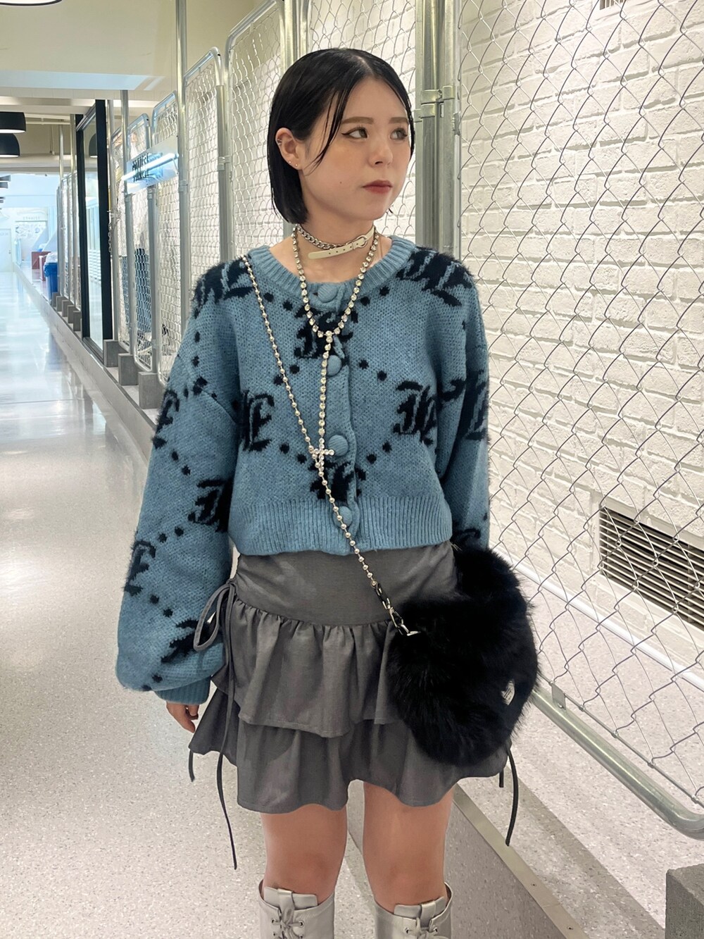 シルバー系のブーツ、ブルー系のカーディガン/ボレロ、ブラック系のハンドバッグを着用したレディースの夏コーディネートの5枚目の写真