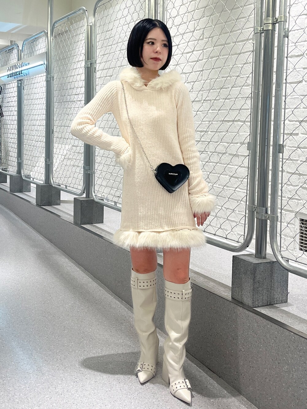 ホワイト系のワンピース、ホワイト系のブーツを着用したレディースの冬コーディネートの2枚目の写真