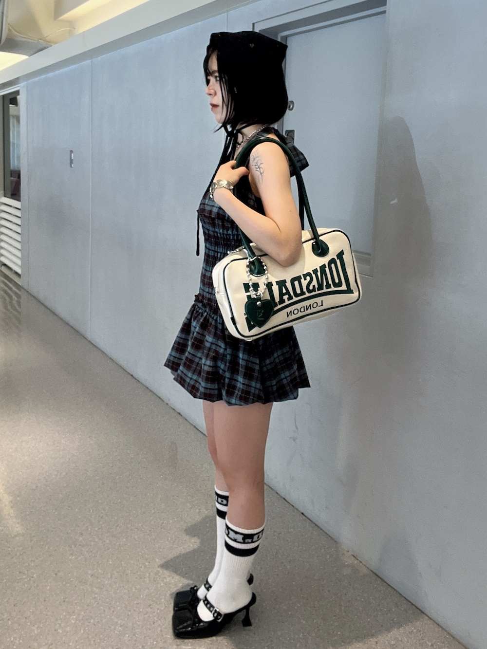 ブラウン系のワンピース、ホワイト系のボストンバッグ、ブラック系のパンプスを着用したレディースの夏コーディネートの3枚目の写真