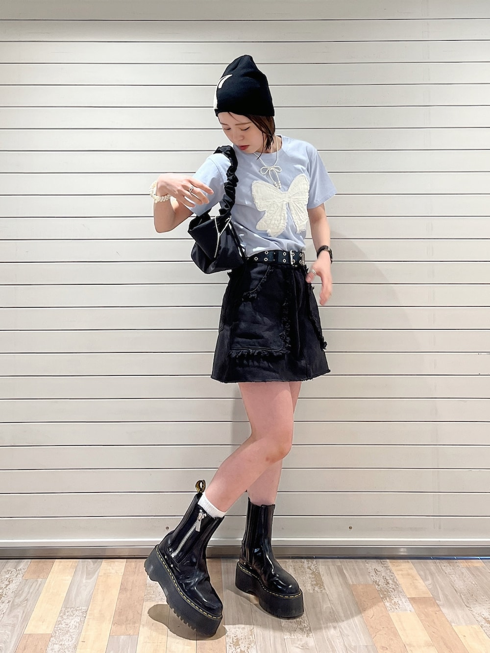 ブラック系のショルダーバッグ、ブラック系のスカート、ブルー系のTシャツ/カットソーを着用したレディースの春コーディネートの2枚目の写真