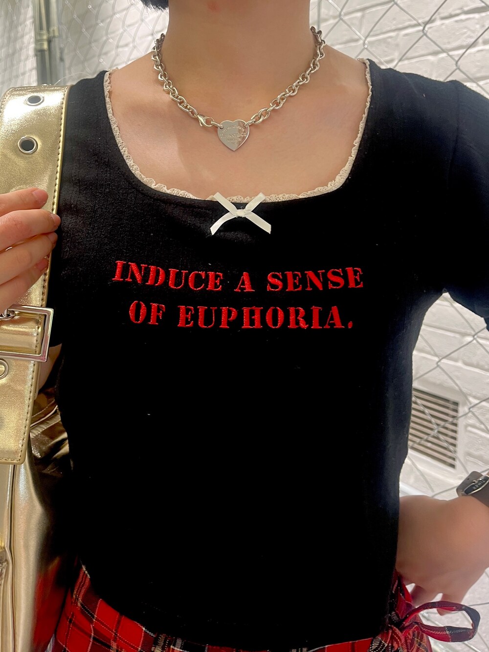 ブラック系のTシャツ/カットソー、レッド系のスカート、ブラック系のパンプスを着用したレディースの夏コーディネートの6枚目の写真