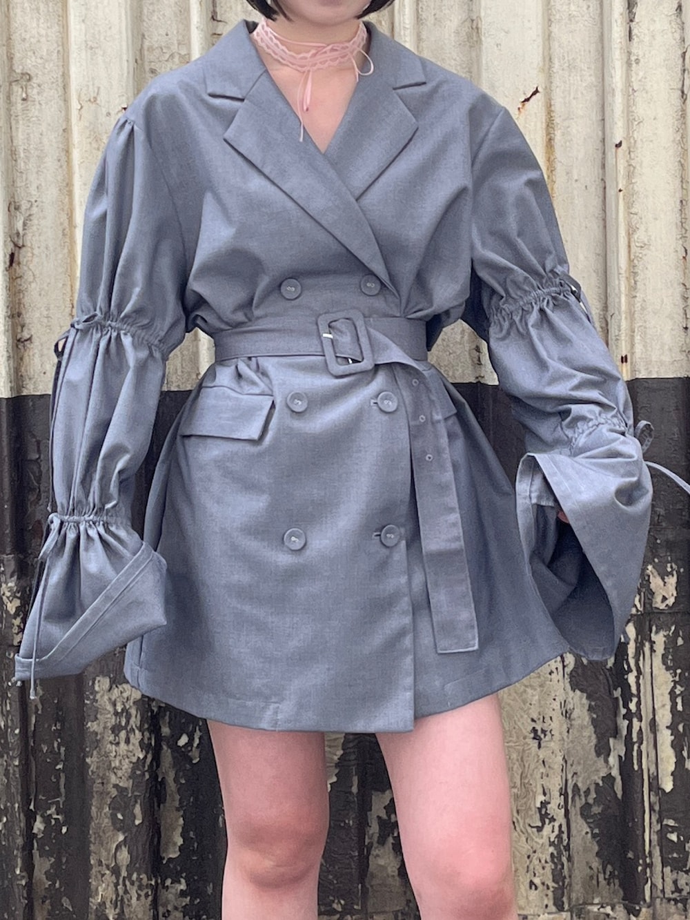 グレー系のテーラードジャケット、ピンク系のチョーカーを着用したレディースの春コーディネートの6枚目の写真