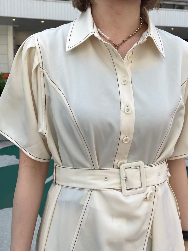 ブラック系のブーツ、ホワイト系のワンピース、ゴールド系のネックレスを着用したレディースの春コーディネートの6枚目の写真